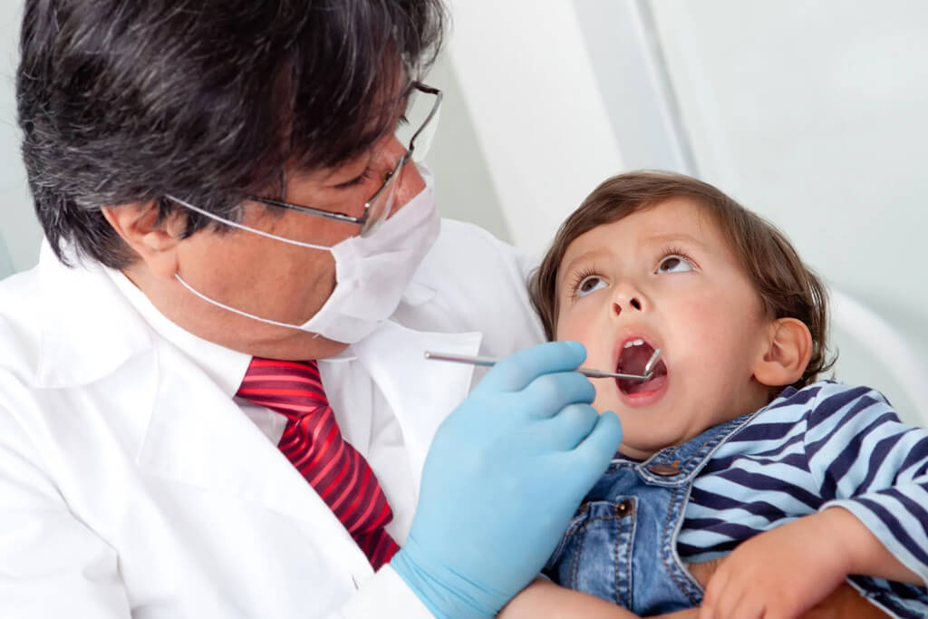 A baby with his pediatrician and smiling