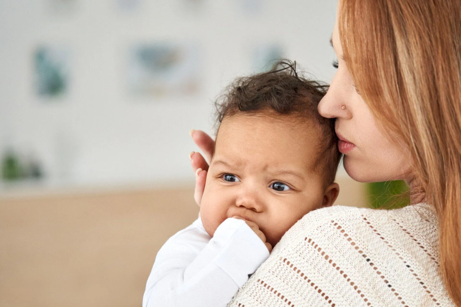 A woman is holding toddler in her hands